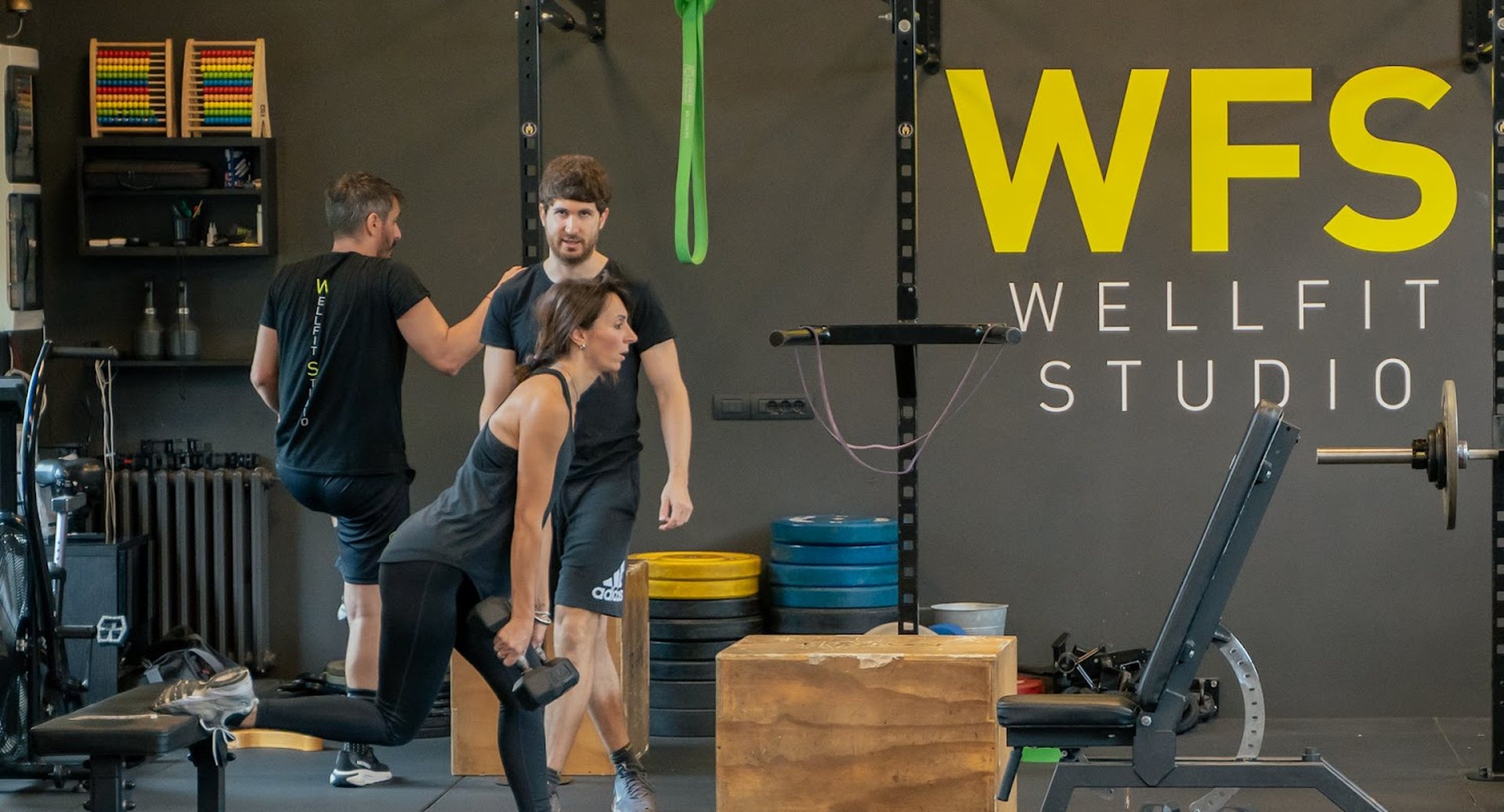 La sala di WellFit Studio a Cesena durante una seduta di personal training, con il logo WFS sulla parete